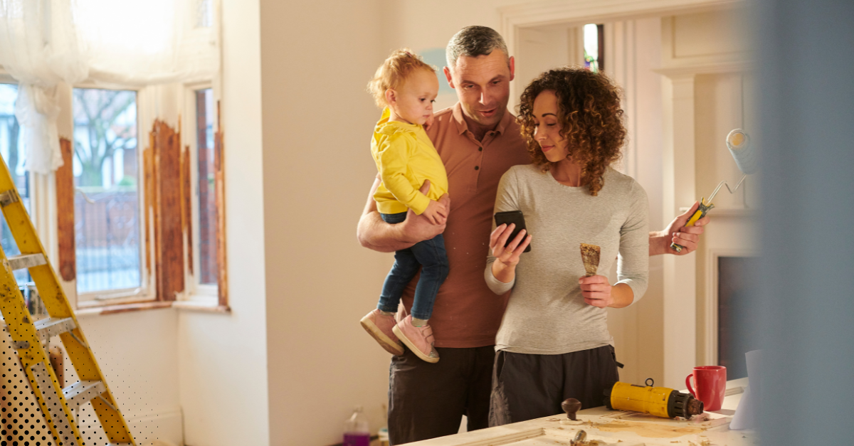 A family reviewing home renovation plans on a phone while working on a home improvement project
