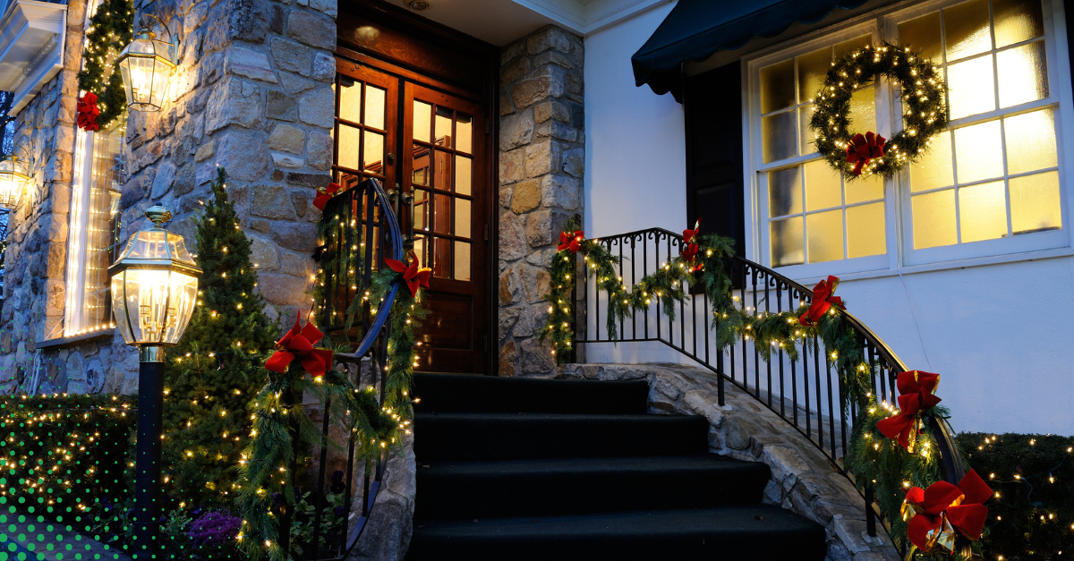 Front entrance decorated with holiday garlands, wreaths, and string lights.