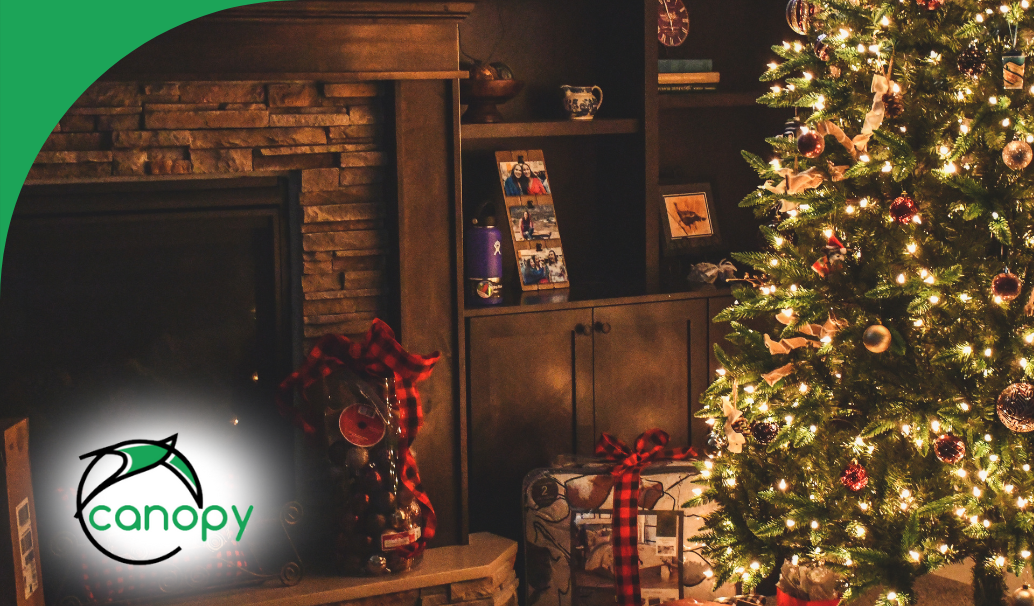 Cozy living room with a decorated Christmas tree, fireplace, and holiday gifts.