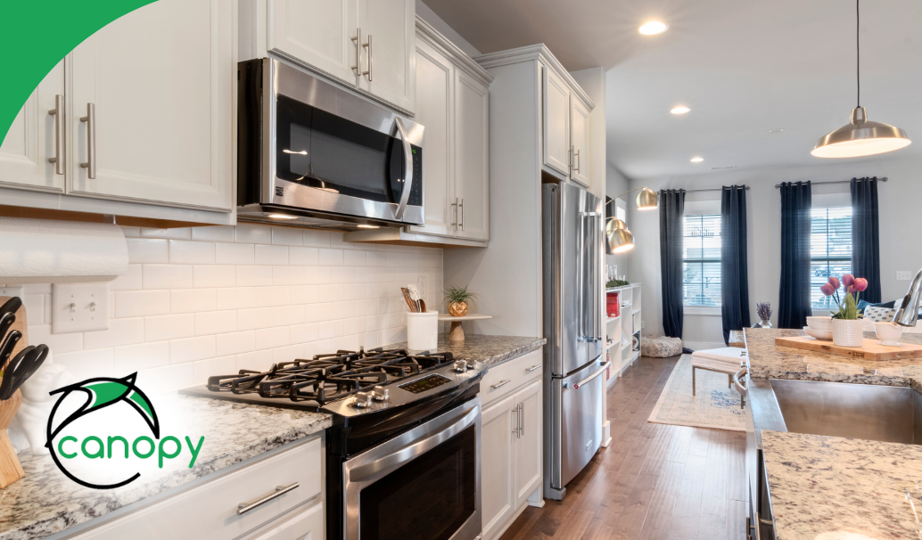 Modern kitchen with white cabinets, stainless steel appliances, and a granite countertop