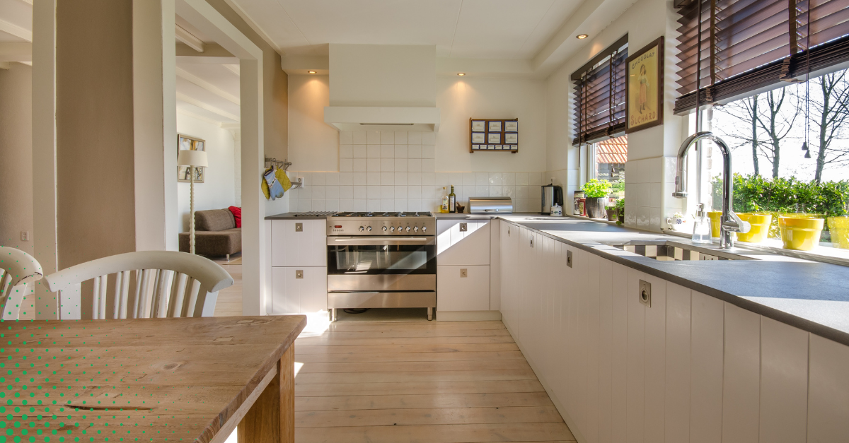 Bright kitchen with white cabinets, stainless steel appliances, and natural wood accents.