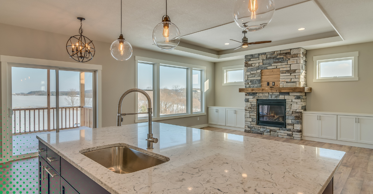 spacious kitchen featuring a marble countertop, modern sink, and pendant lighting.