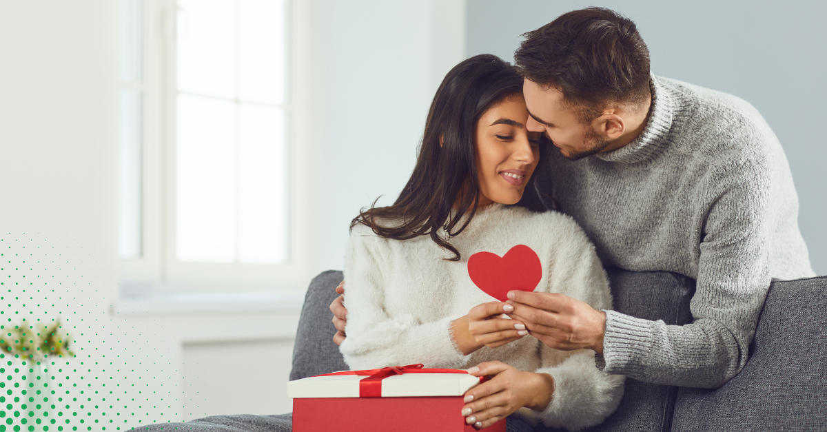 Romantic couple celebrating Valentine's Day at home, exchanging heartfelt gifts and creating special moments together.