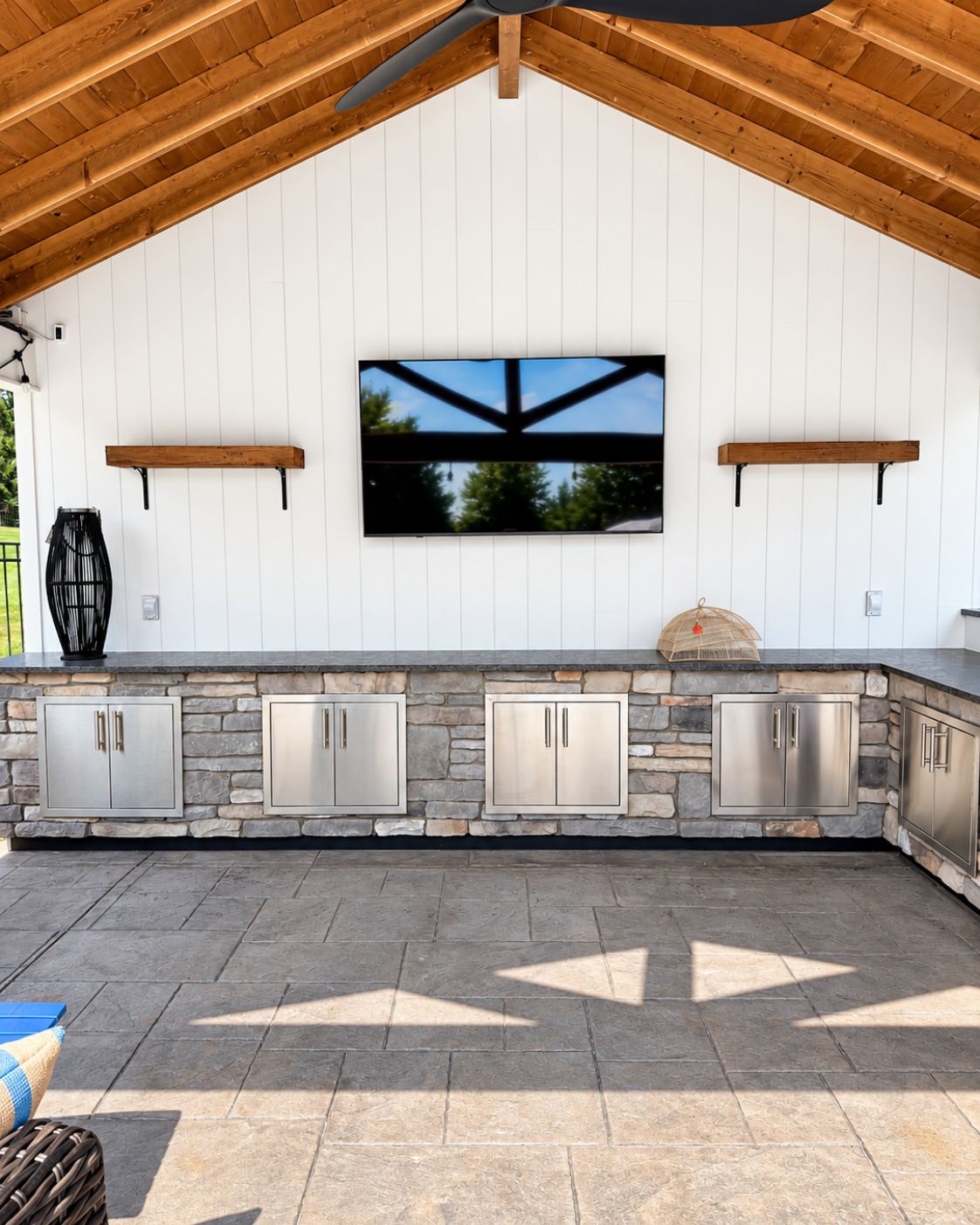 Stacked-stone veneer bar base with LED underlighting and ambient string lights by Canopy Building Services