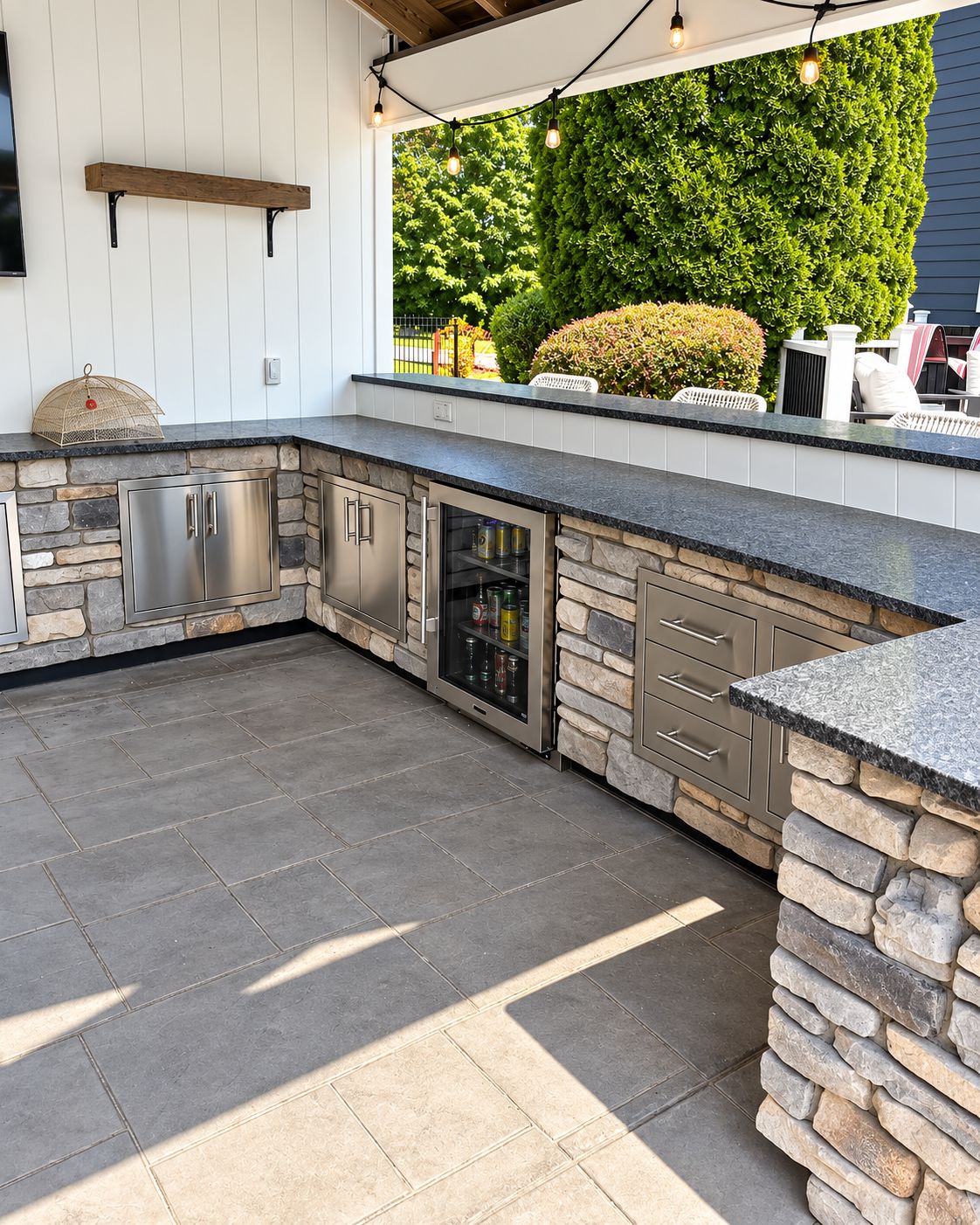 Outdoor bar area with built-in refrigerator and stainless-steel cabinetry by Canopy Building Services