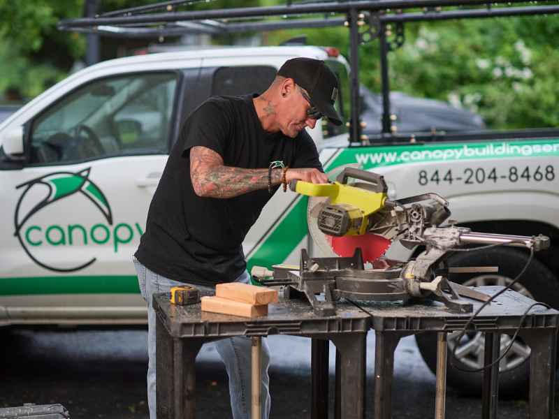 Canopy Building Services carpenter cutting lumber on a job site in Delaware County, PA